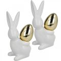 Floristik24 Lapins avec oeuf d&#39;or, lapins en céramique pour Pâques blanc noble, doré H13cm 2pcs